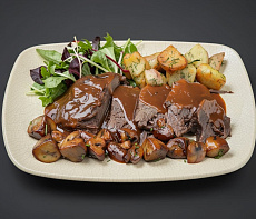 Оленина на овощной подушке под пряным соусом